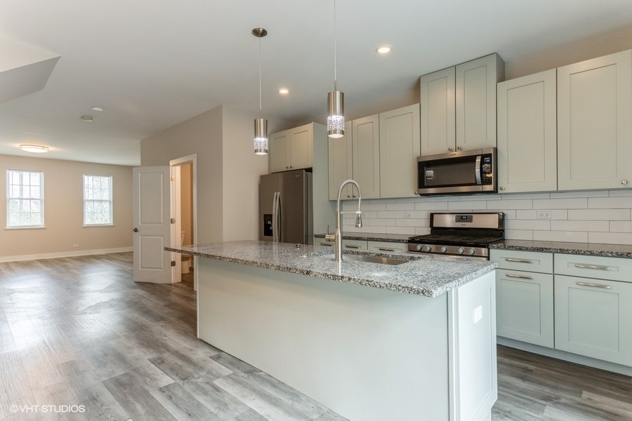 10604 Alice Mae Court Orland Park, IL 60462 - Photo 2 of 14 a kitchen with stainless steel appliances granite countertop a sink a stove a refrigerator and a microwave