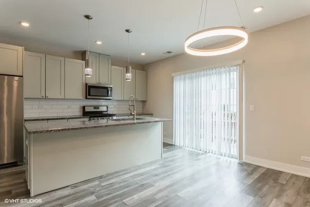 a kitchen with stainless steel appliances a refrigerator a sink a stove a microwave and island