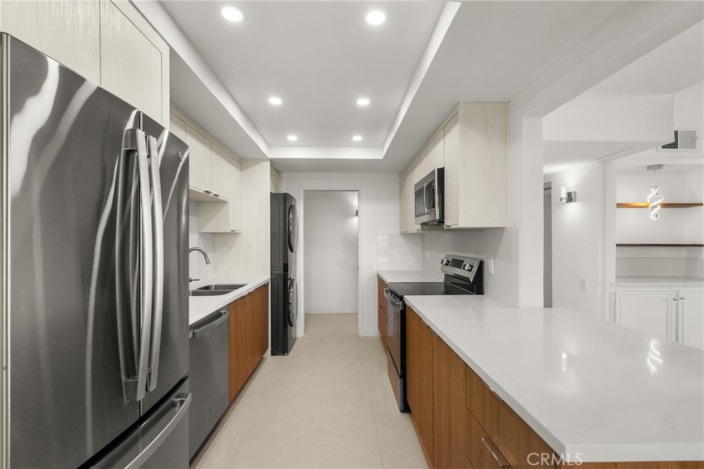 2385 Roscomare Road, Unit F16 Los Angeles, CA 90077 - Photo 11 of 39 a kitchen with stainless steel appliances granite countertop a refrigerator a stove and a sink