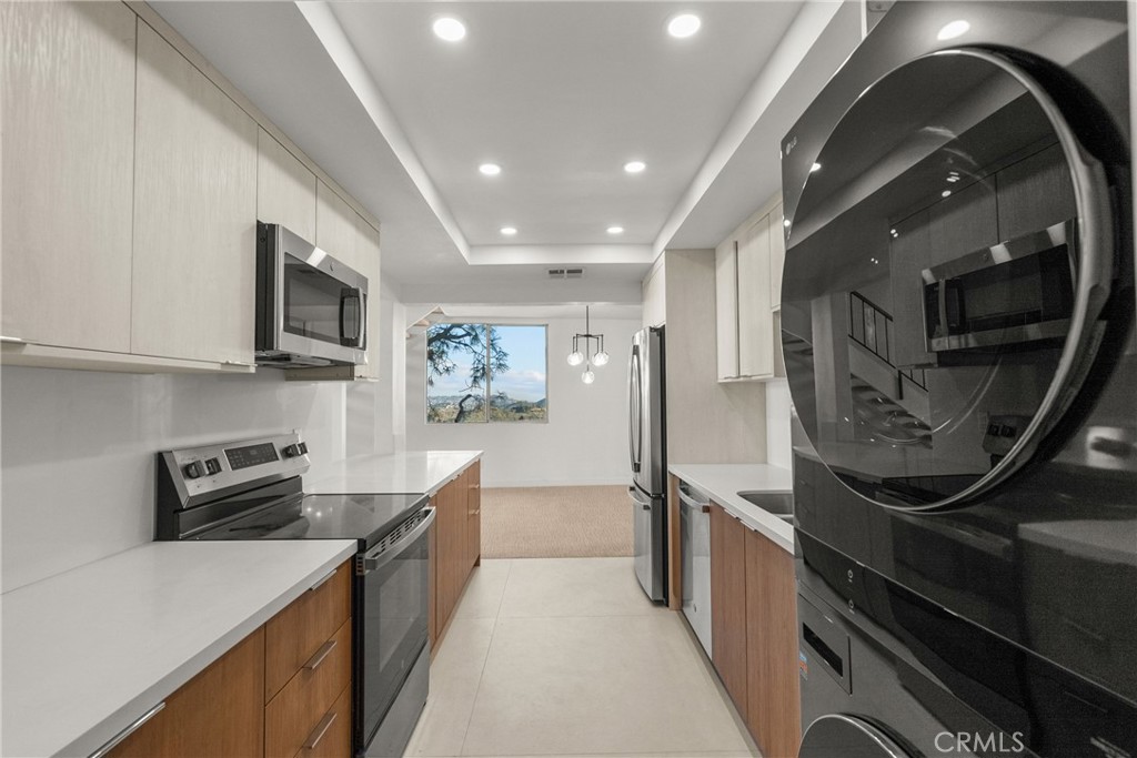 2385 Roscomare Road, Unit F16 Los Angeles, CA 90077 - Photo 12 of 39 a kitchen with stainless steel appliances a sink stove and cabinets