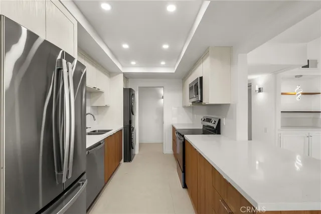 a kitchen with stainless steel appliances granite countertop a refrigerator a stove and a sink