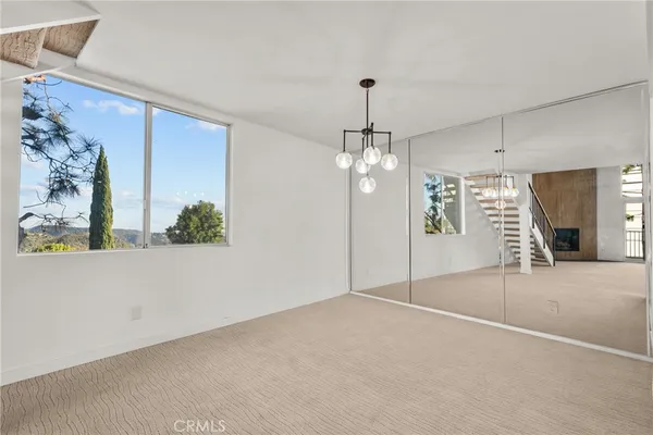 en empty room with windows and chandelier