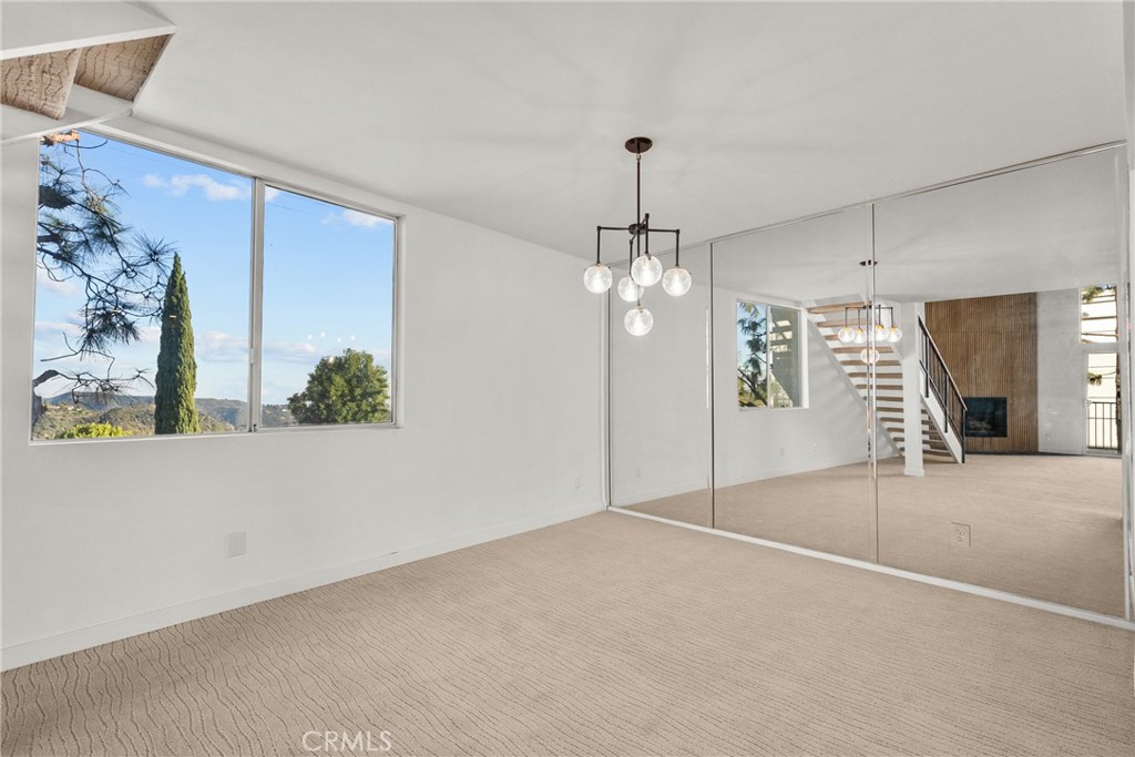 2385 Roscomare Road, Unit F16 Los Angeles, CA 90077 - Photo 14 of 39 en empty room with windows and chandelier