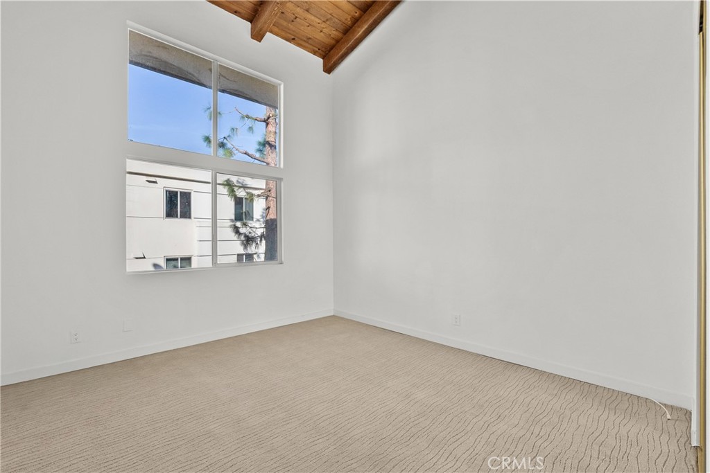 2385 Roscomare Road, Unit F16 Los Angeles, CA 90077 - Photo 22 of 39 an empty room with a fireplace and wooden floor