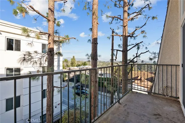 a view of a balcony with a potted plant and street view