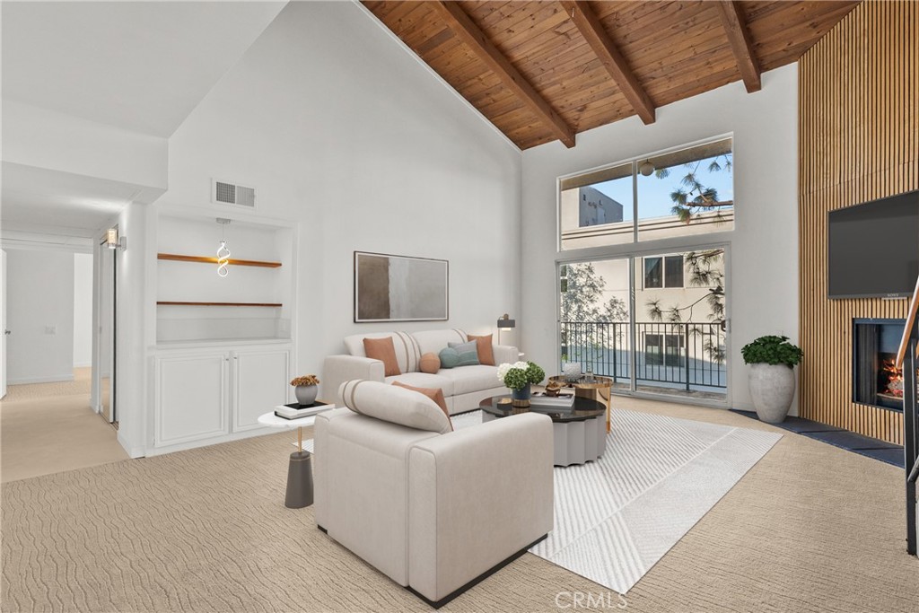 2385 Roscomare Road, Unit F16 Los Angeles, CA 90077 - Photo 3 of 39 a living room with furniture a flat screen tv and a floor to ceiling window