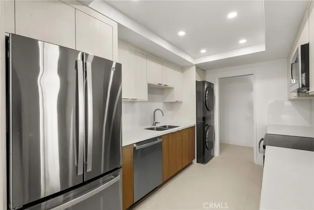a kitchen with stainless steel appliances granite countertop a refrigerator and a sink