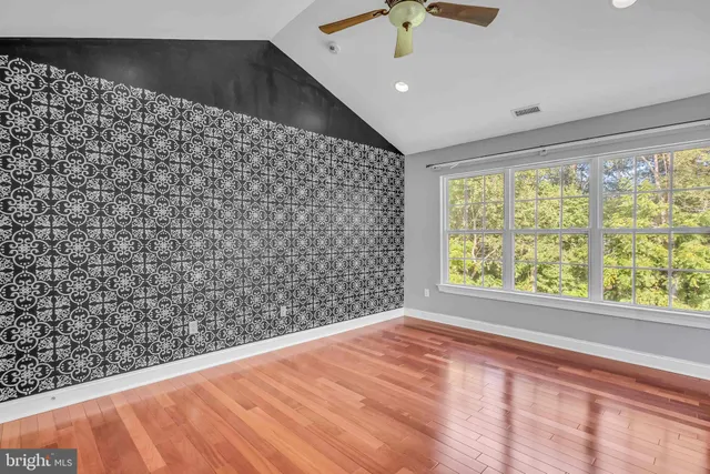 a view of empty room with a window and ceiling fan