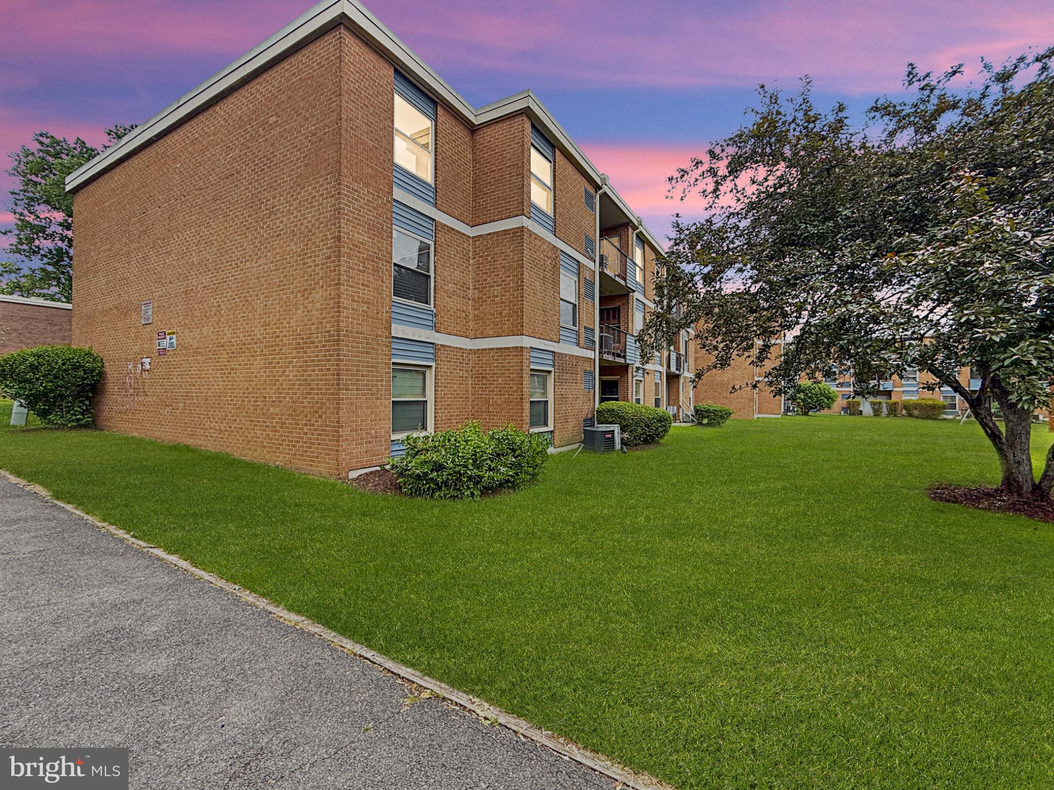 Charming brick apartment with lush lawn.