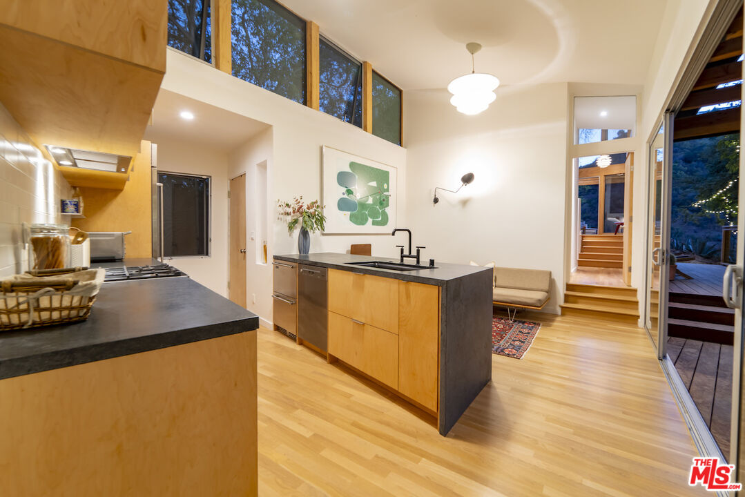 1847 Calgary Lane Los Angeles, CA 90077 - Photo 11 of 43 a kitchen with kitchen island a counter top space a sink a stove and a wooden floor