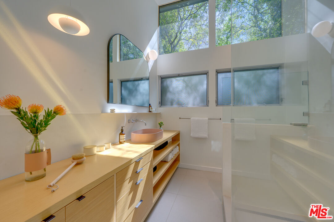 1847 Calgary Lane Los Angeles, CA 90077 - Photo 31 of 43 a bathroom with a double vanity sink a mirror and a bathtub