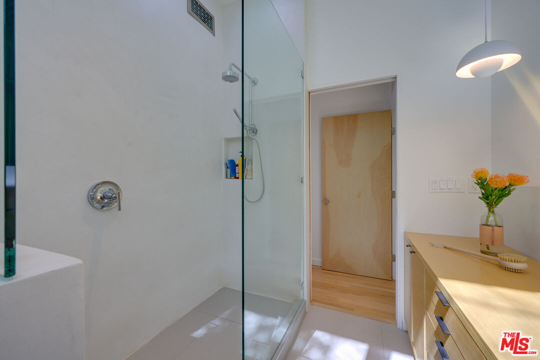 1847 Calgary Lane Los Angeles, CA 90077 - Photo 32 of 43 a bathroom with a granite countertop sink a mirror and a shower