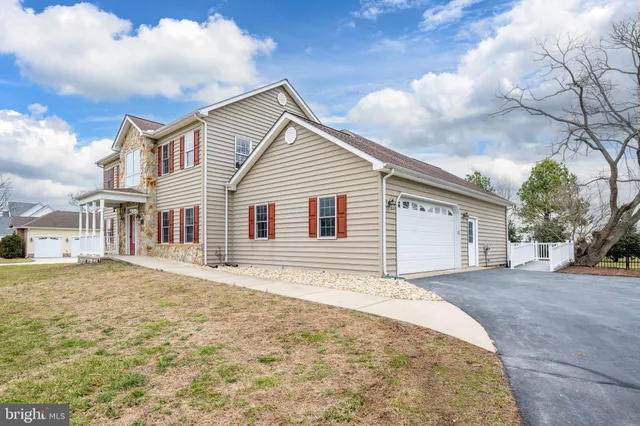 a large kitchen with sink a refrigerator and white cabinets