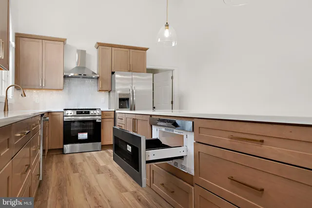 an empty room with windows and fireplace