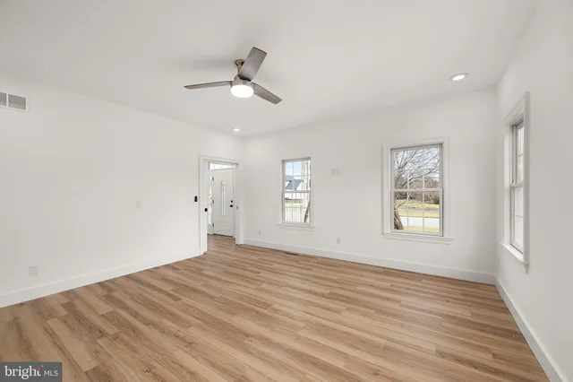 a view of a room with wooden floor and white walls