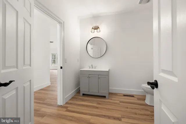 a view of a big room with windows and chandelier fan