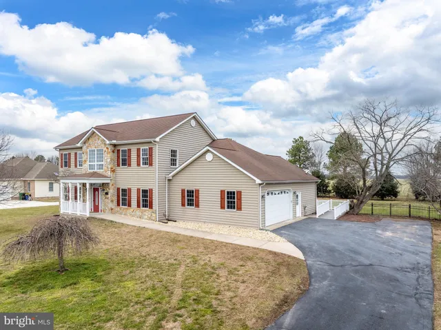 a front view of a house with a yard covered with snow