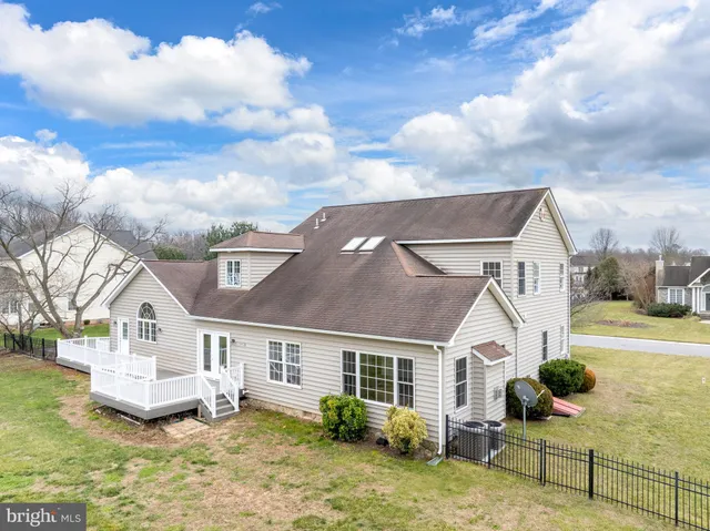 a large kitchen with kitchen island a sink dishwasher stove and white cabinets with wooden floor
