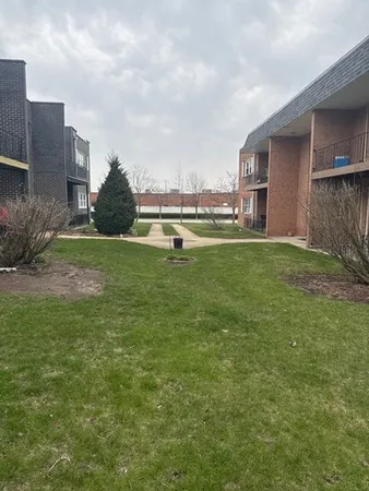 a view of a house with a yard and sitting area