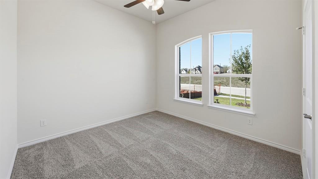 4163 Waldron Trail Forney, TX 75126 - Photo 19 of 30 Carpeted room featuring two arched windows, a ceiling fan with integrated lighting, and a white paneled door