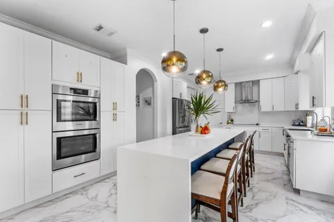 a kitchen with white cabinets and stainless steel appliances