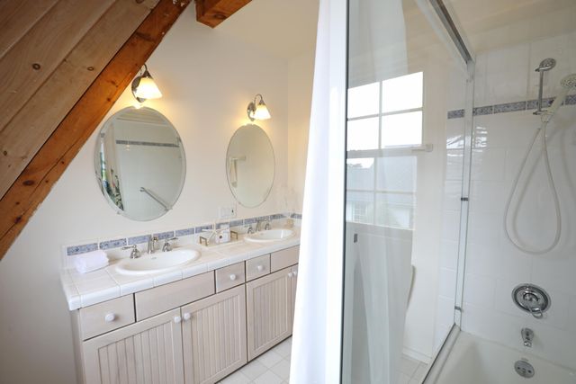 a bathroom with a double vanity sink mirror and a shower