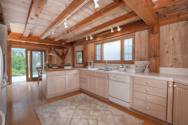 a large white kitchen with a large window