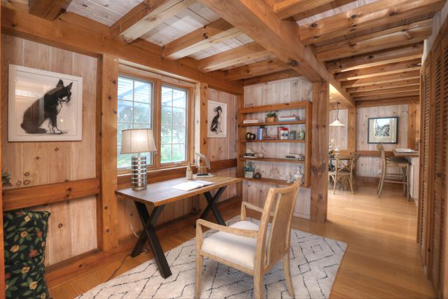 a dining room with wooden floor and a chandelier