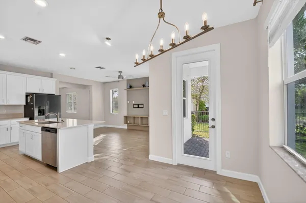 a living room with stainless steel appliances kitchen island granite countertop a refrigerator and a stove top oven