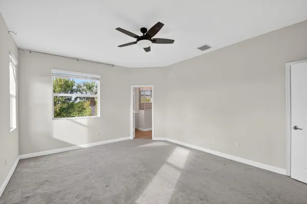 a view of a big room with a window and a ceiling fan