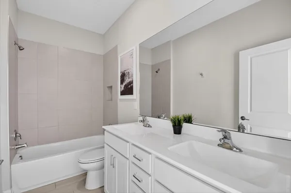 a bathroom with a double vanity sink toilet and shower