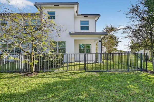 a view of a house with a small yard and wooden fence