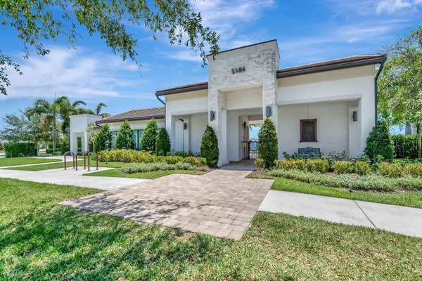 a view of a house with a yard and potted plants