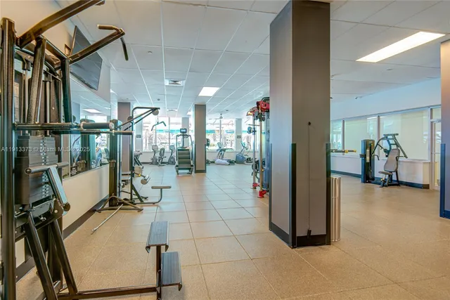 a view of a room with gym equipment and floor to ceiling windows