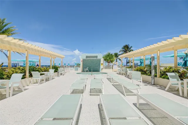a view of a yard with a table and chairs under an umbrella