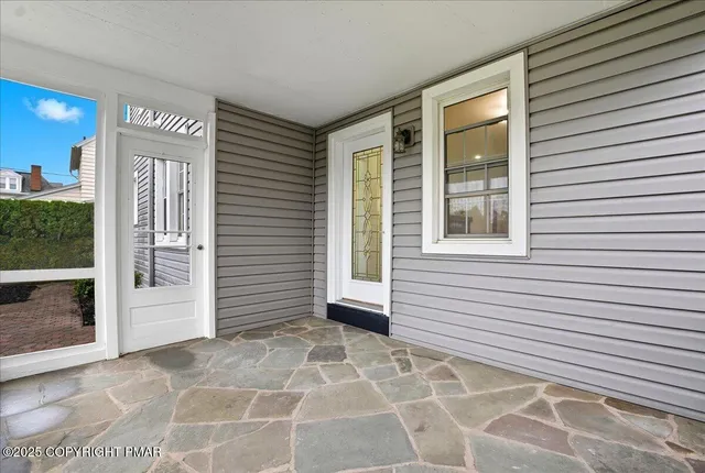 a view of an empty room with wooden floor fireplace and a window