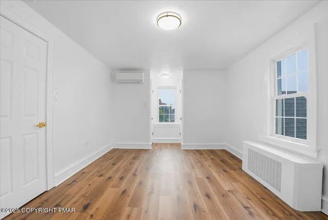 a view of a livingroom with wooden floor and a potted plant