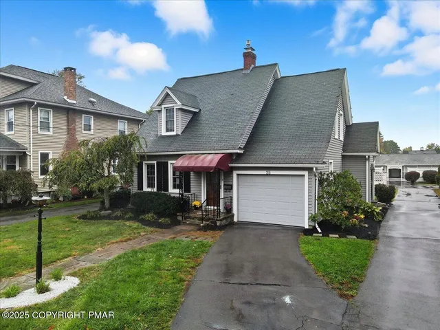 a front view of a house with a yard and trees