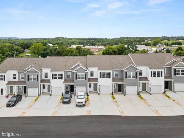 a view of a white house with a yard and potted plants