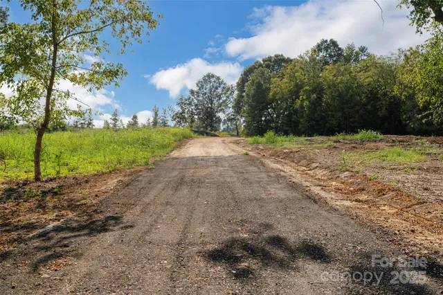 a view of a dirt road and a building