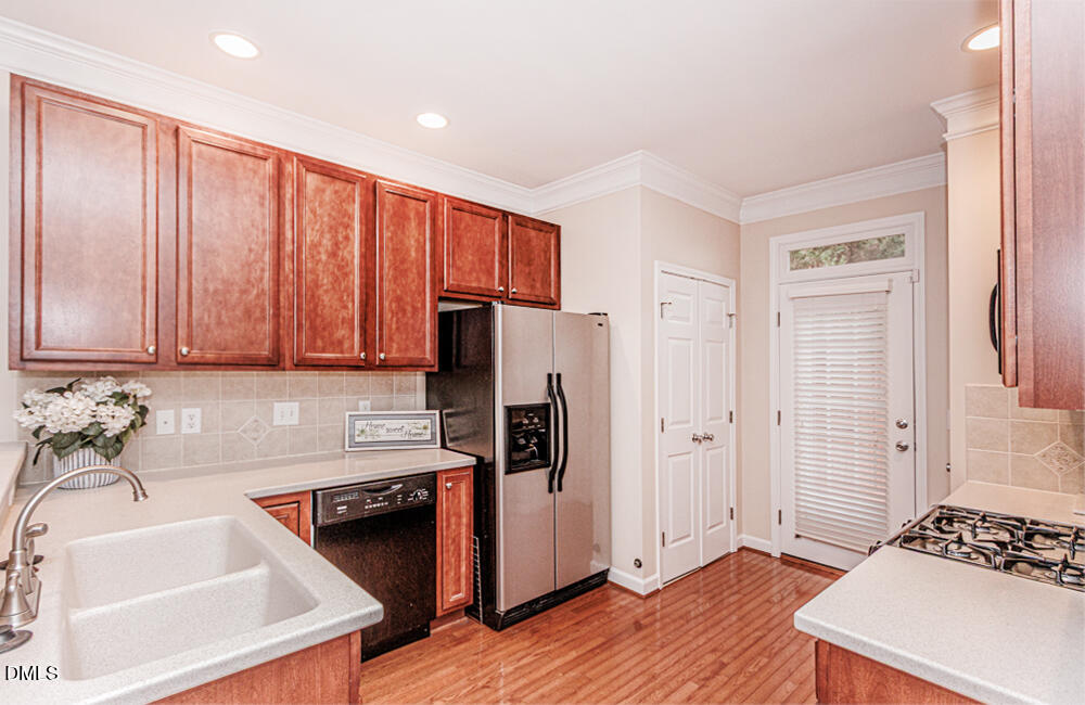 6016 Four Townes Lane Raleigh, NC 27616 - Photo 14 of 32 a kitchen with stainless steel appliances granite countertop a refrigerator a sink and dishwasher with wooden floor