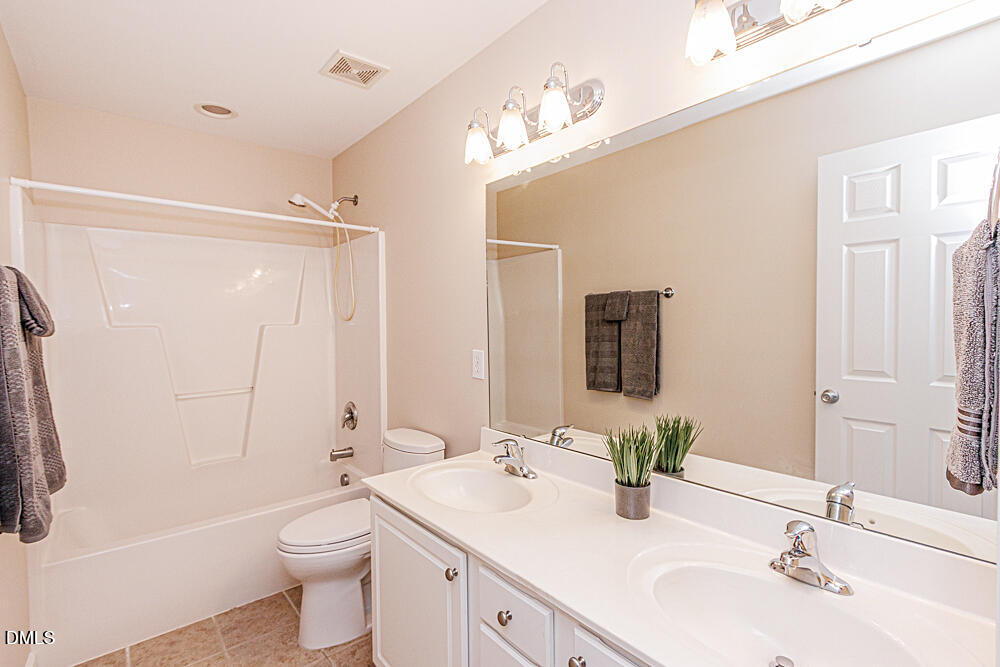 6016 Four Townes Lane Raleigh, NC 27616 - Photo 27 of 32 a bathroom with a double vanity sink toilet and shower