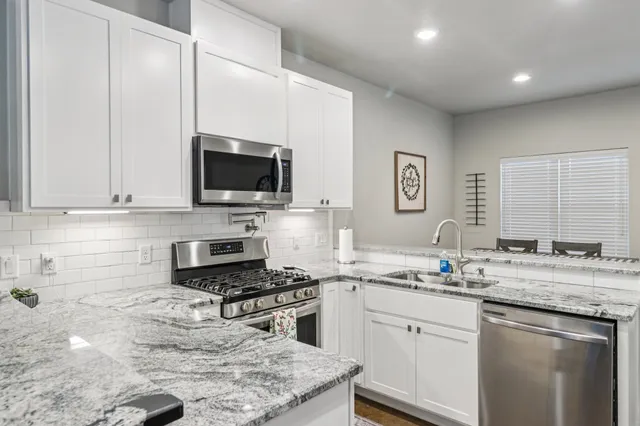 a large kitchen with a stove a sink and a microwave