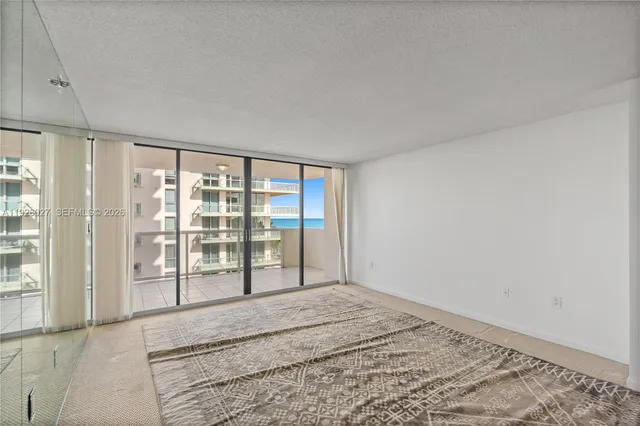 an empty room with windows and view of balcony