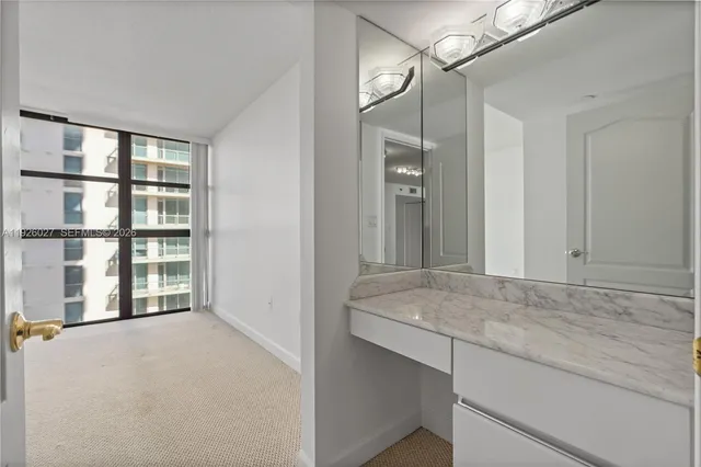 a living room with furniture a floor to ceiling window and wooden floor