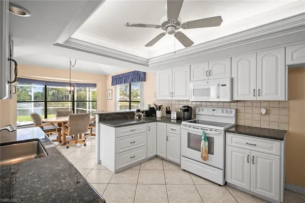a kitchen with white cabinets and white appliances