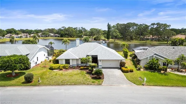 an aerial view of a house with outdoor space and lake view in back