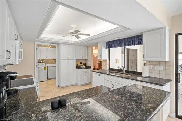 a large living room with stainless steel appliances granite countertop furniture and a kitchen view