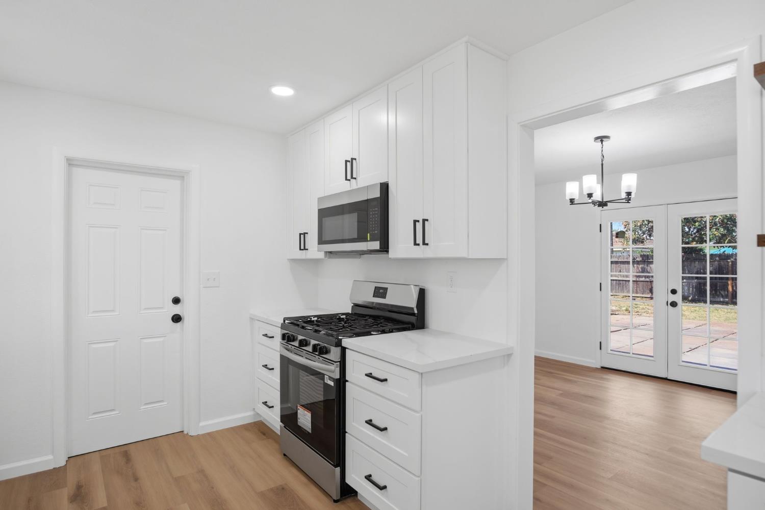 1451 Kent Way Modesto, CA 95355 - Photo 13 of 37 a kitchen with granite countertop a sink cabinets and wooden floor