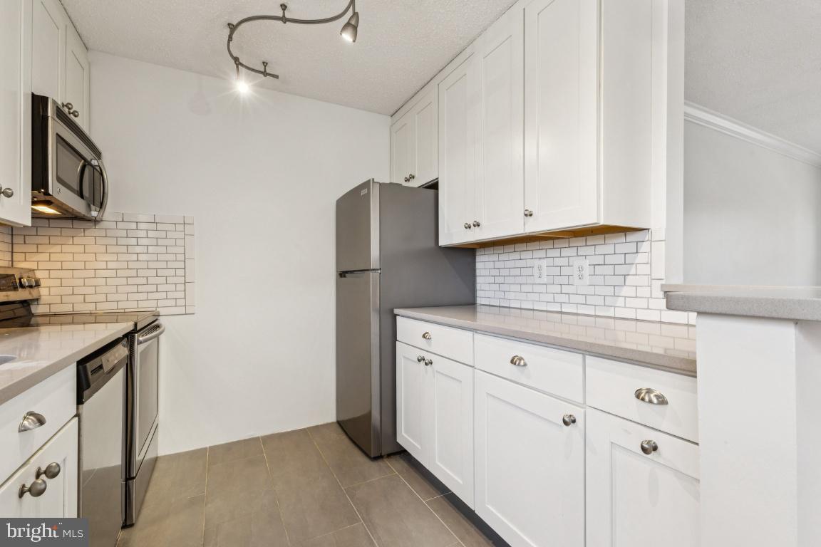 1620 West Abingdon Drive, Unit 301 Alexandria, VA 22314 - Photo 6 of 24 a kitchen with stainless steel appliances white cabinets and a sink